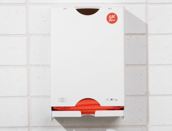 White and red water heater mounted on a tiled wall